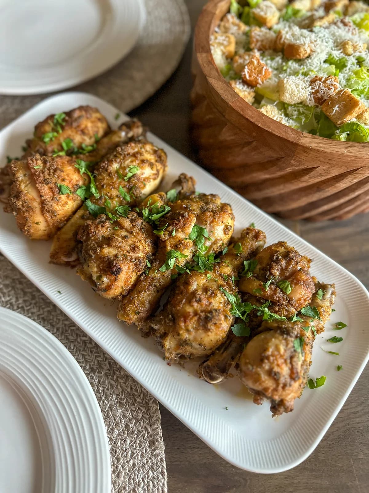 Crispy baked chicken wings tossed in sauce on parchment
