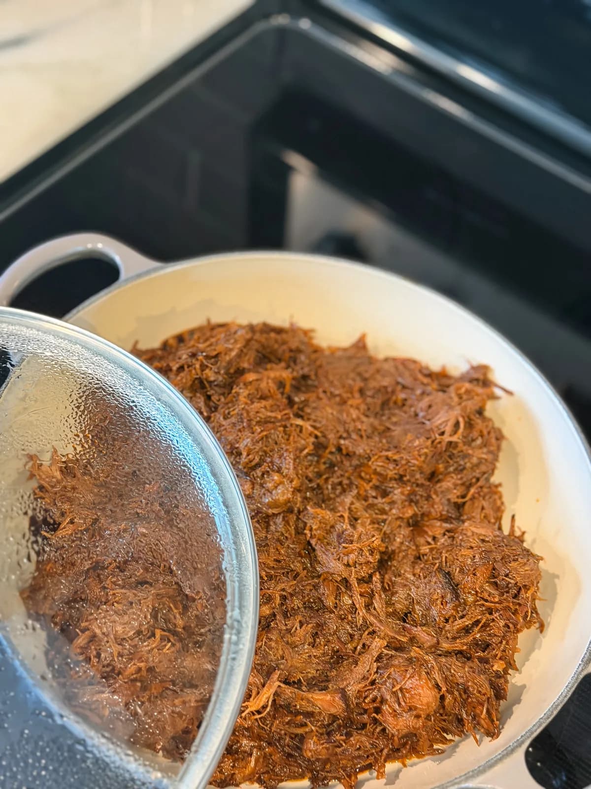 A smoked bbq roast resting on a wooden board with a thick crust