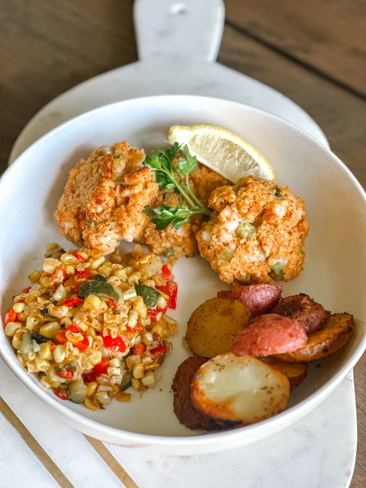 Golden pan-seared crab cakes plated with a wedge of lemon