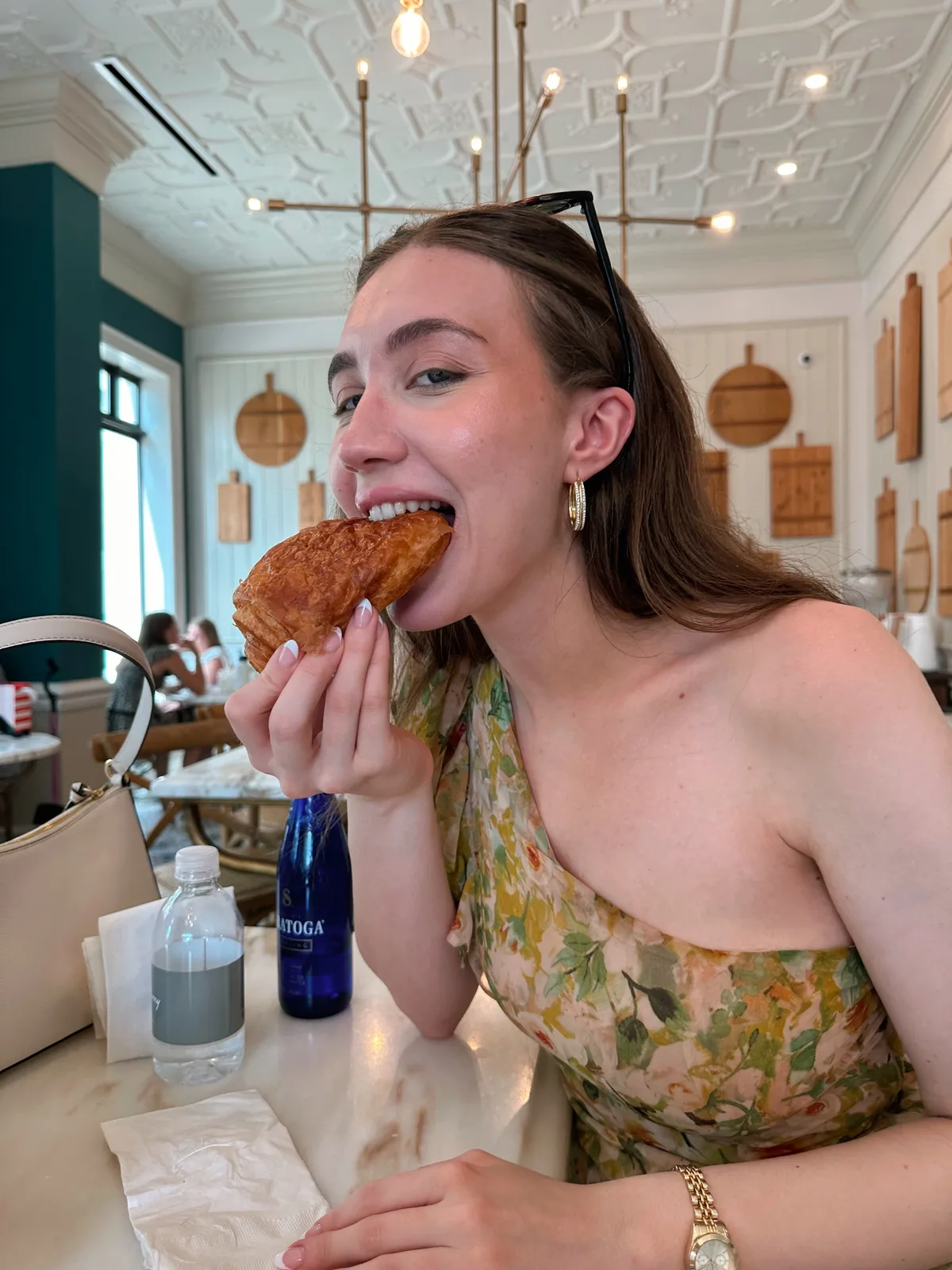 Eating a flaky pastry, mid-bite, candid moment