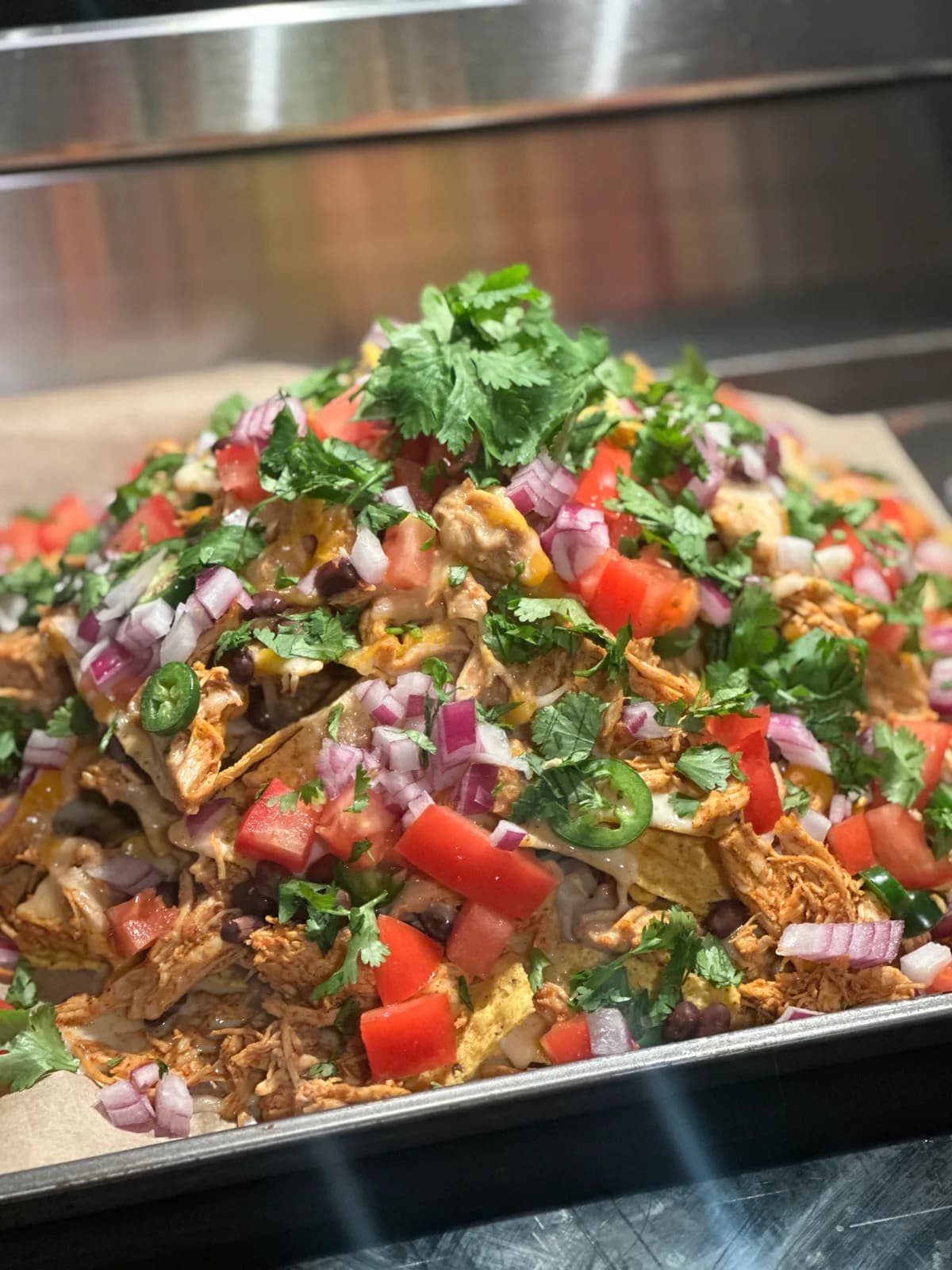 A platter of loaded nachos with melted cheese and toppings