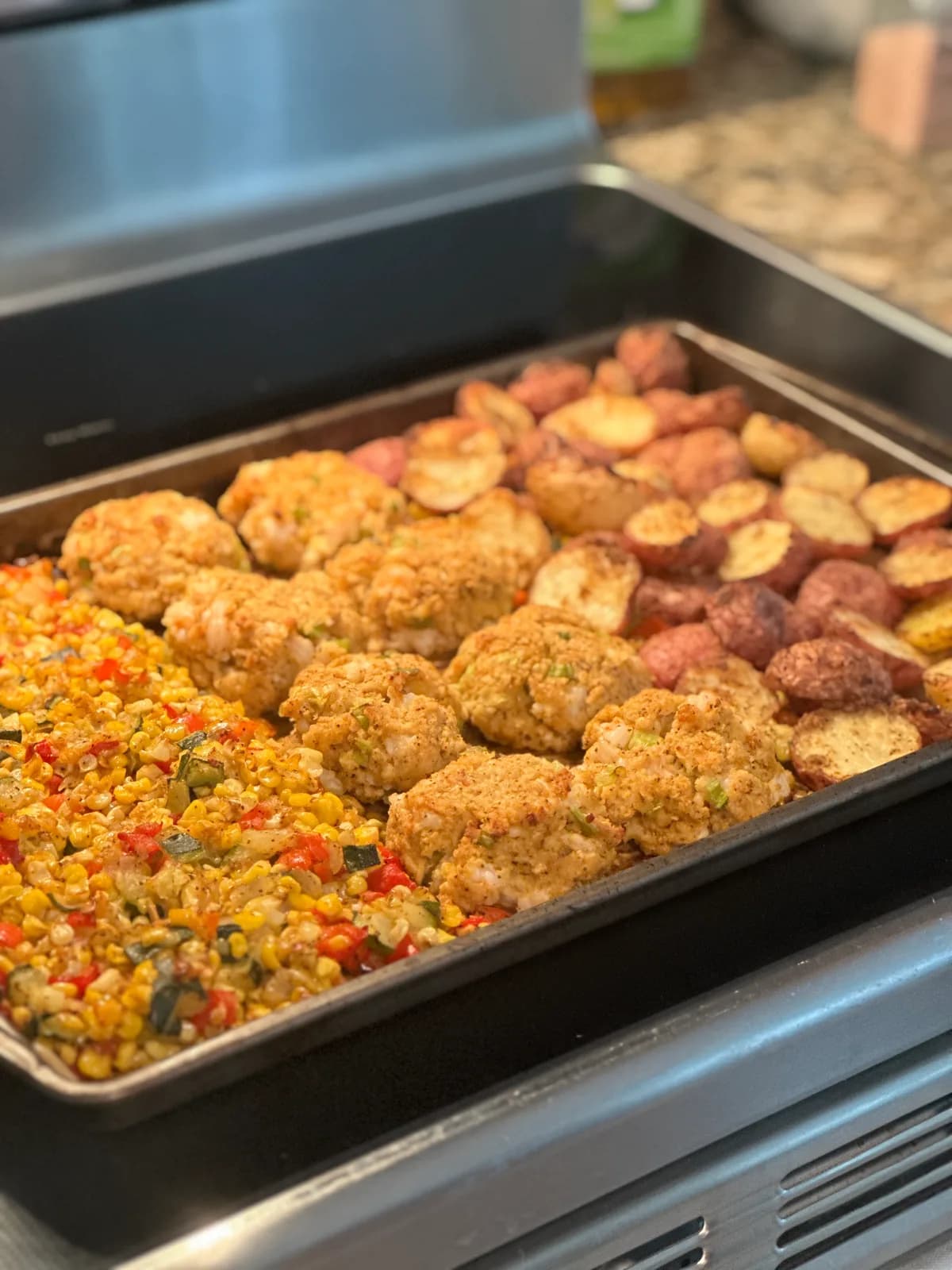 A new england sheet pan dinner with seafood, corn, and potatoes