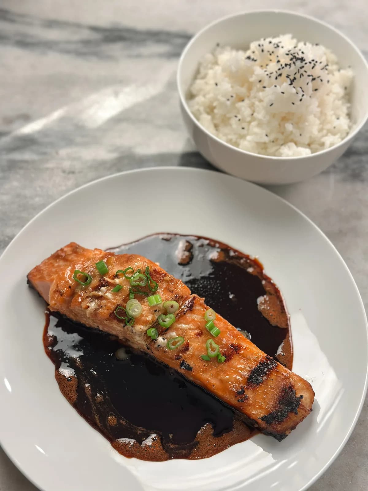 A glossy fillet of salmon plated with lemon