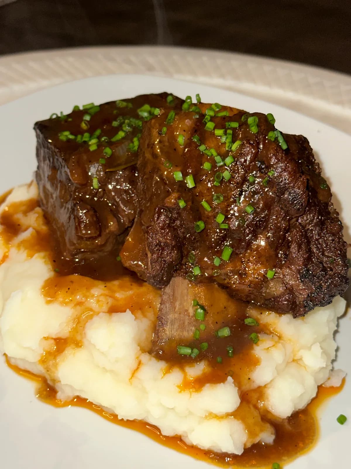 Braised short ribs glistening on a plate