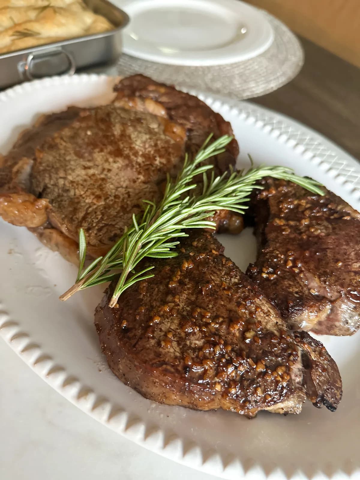 A perfectly cooked steak plated with sides on a ceramic dish