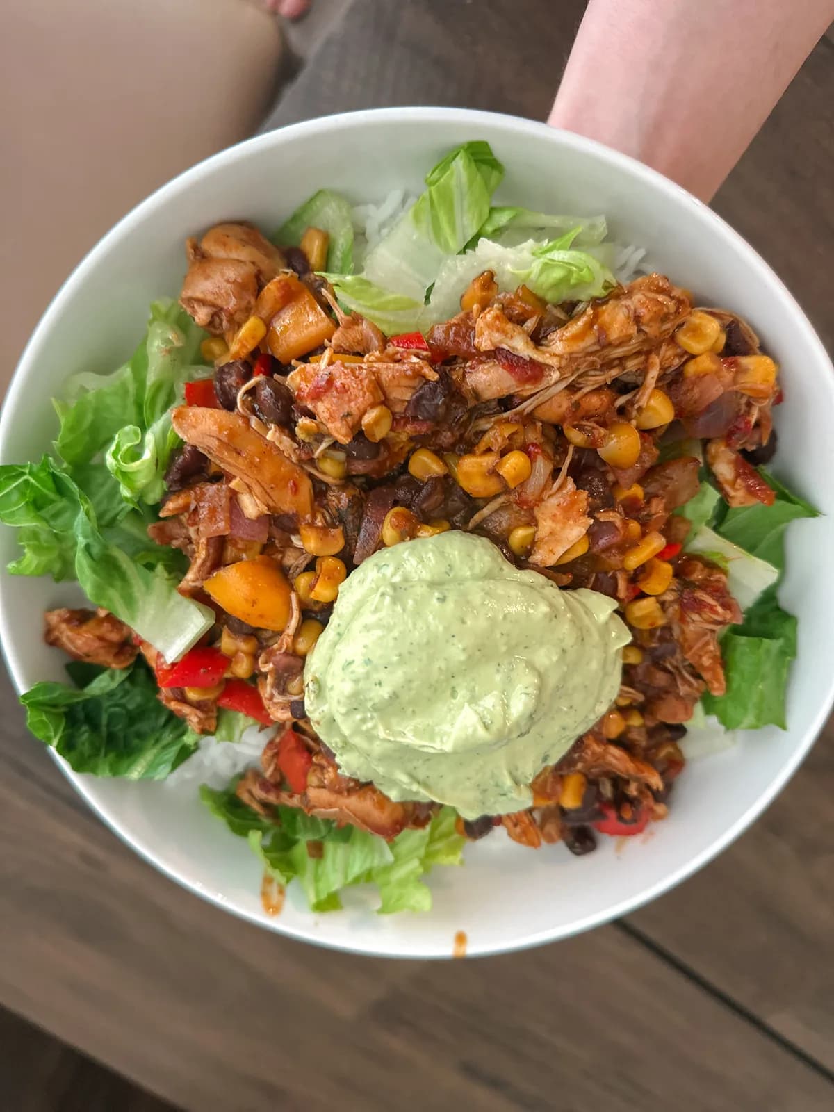 A taco bowl loaded with rice, beans, meat, and toppings
