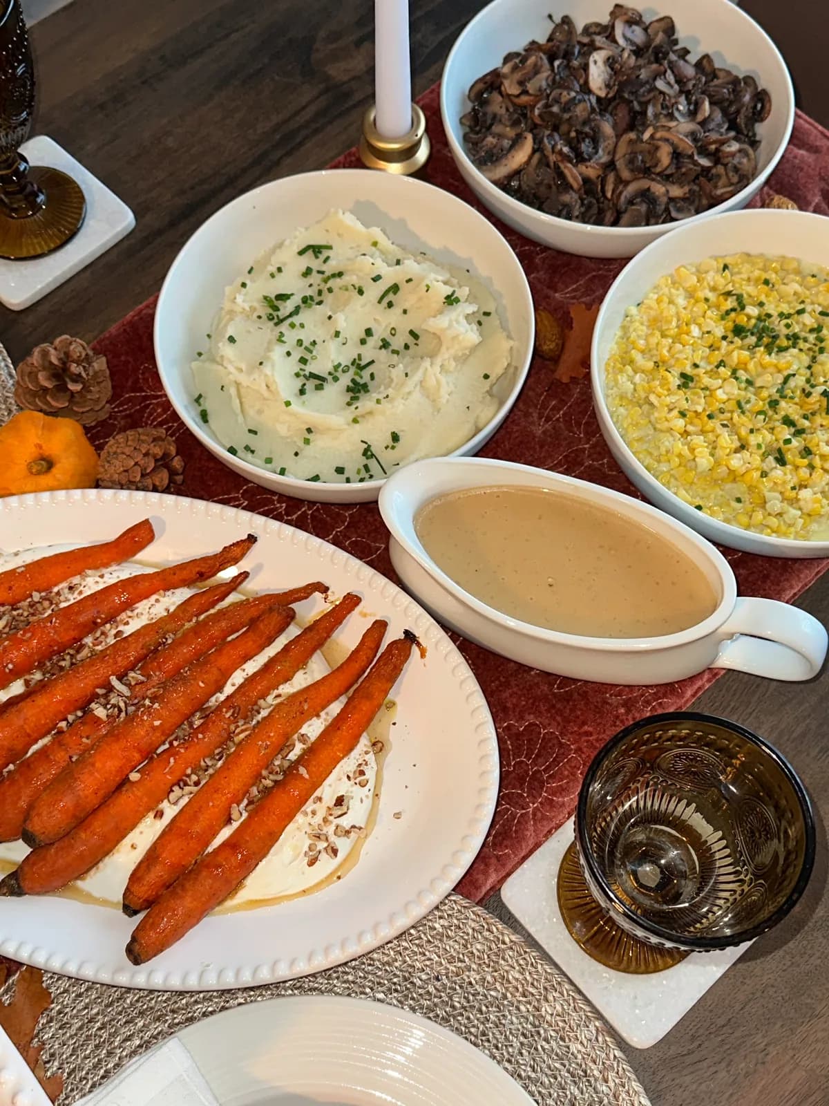 A full thanksgiving spread with turkey, sides, and candles on a holiday table