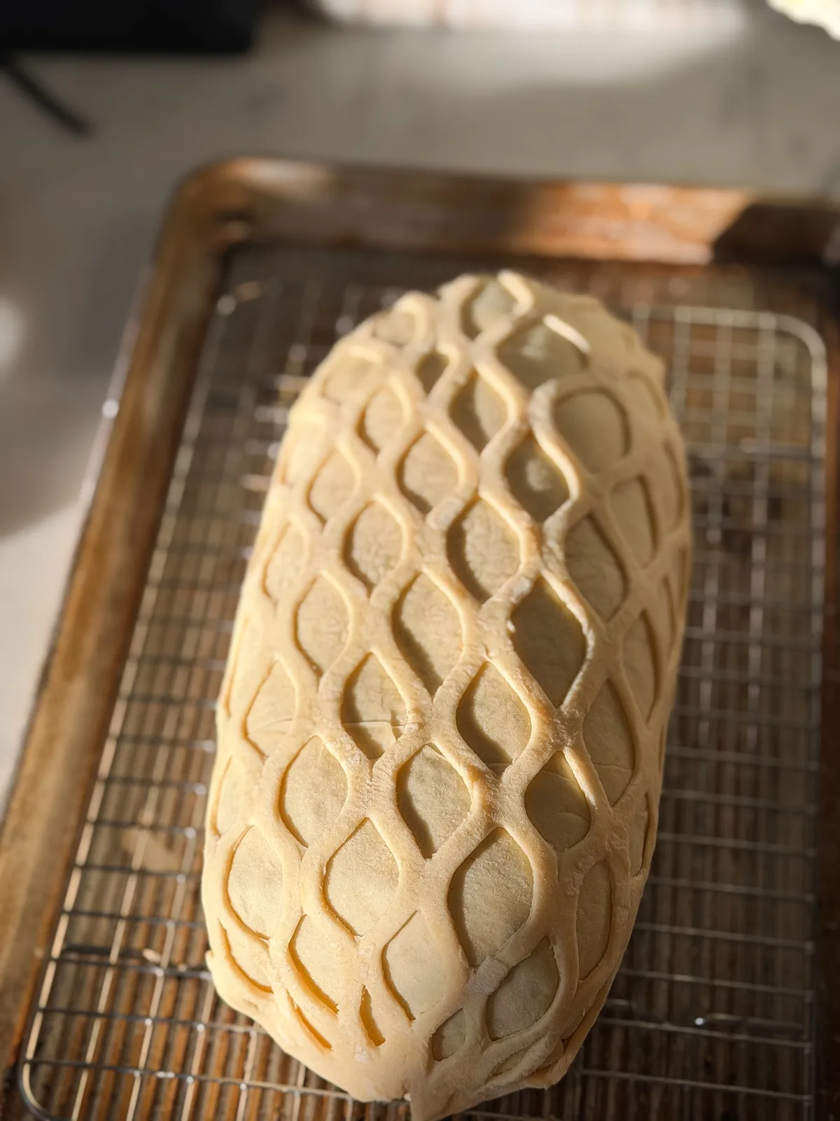 A wrapped beef wellington ready to bake, with pastry latticework